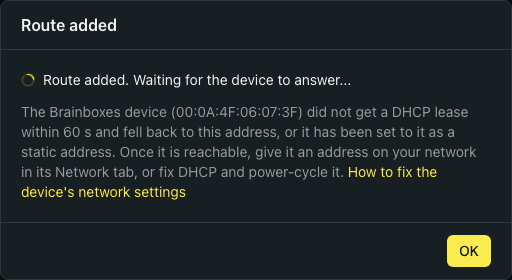 The Route added dialog: a spinner beside 'Route added. Waiting for the device to answer...', then an explanation that the device did not get a DHCP lease within 60 s and fell back to this address, or has been set to it as a static address, with advice to give it an address on your network in its Network tab, or fix DHCP and power-cycle it. An OK button at the bottom right.