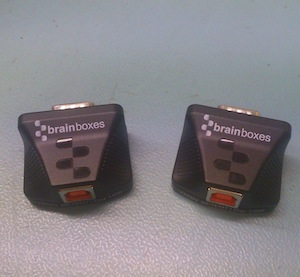 Brainboxes US-235 and US-320 USB to serial adapters side by side, showing DB9 connectors and USB ports